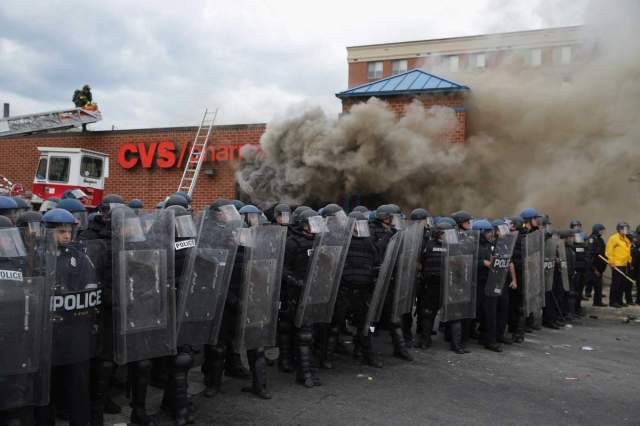 BALTIMORE, MD - APRIL 27: Baltimore Police form a parimeter around a CVS pharmacy that was looted and burned near the corner of Pennsylvania and North avenues during violent protests following the funeral of Freddie Gray April 27, 2015 in Baltimore, Maryland. Gray, 25, who was arrested for possessing a switch blade knife April 12 outside the Gilmor Homes housing project on Baltimore's west side. According to his attorney, Gray died a week later in the hospital from a severe spinal cord injury he received while in police custody.  (Photo by Chip Somodevilla/Getty Images)